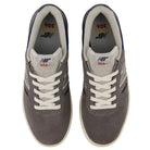 Top view of a pair of gray Jamie Foy Cup 306 CON New Balance Numeric Suede Skateboarding Shoes featuring white laces, white and navy trim, and New Balance branding on the tongues and insoles. These durable suede skate shoes include a rubber cup outsole designed for superior grip and board feel. The shoes are positioned side by side on a white background.