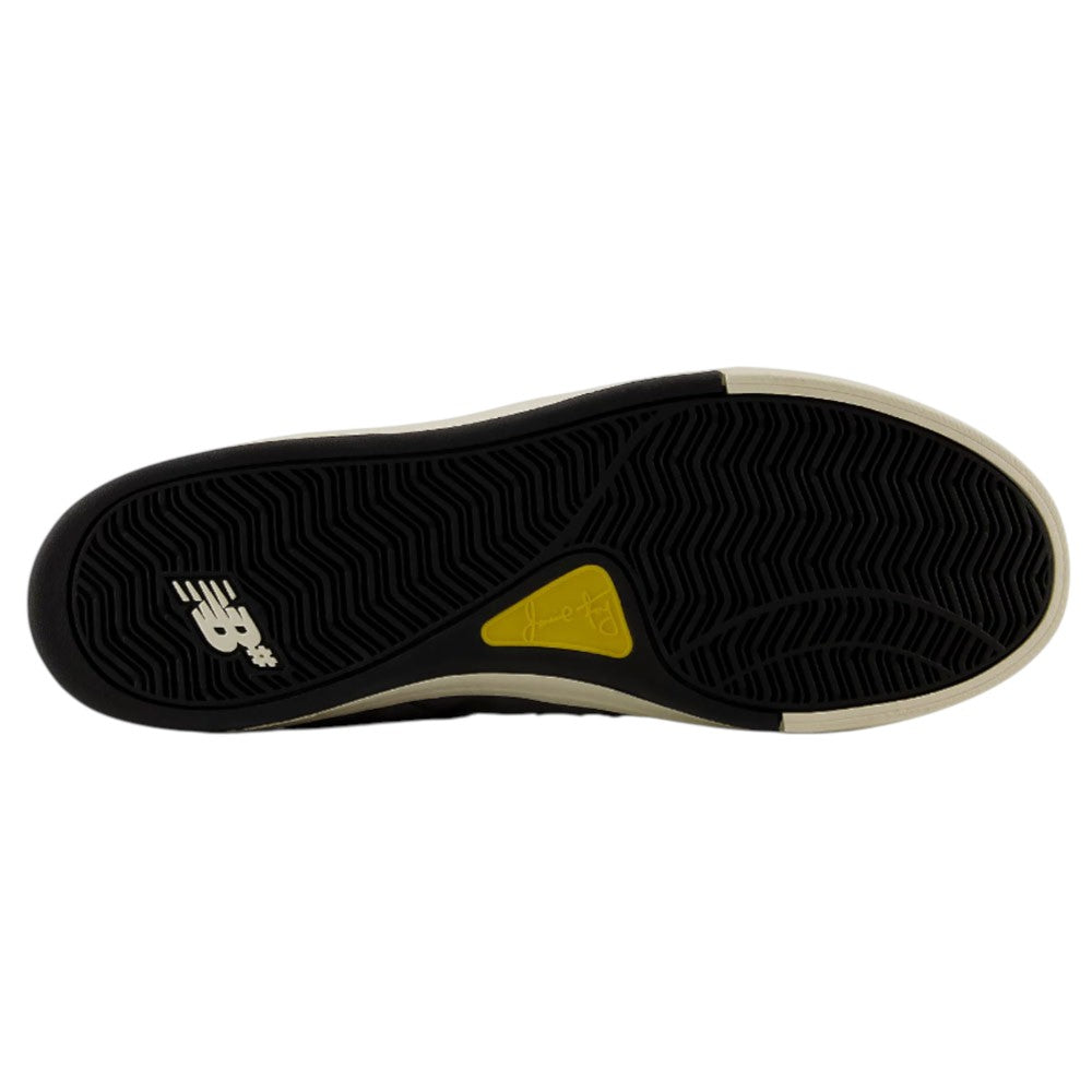 The image features the black rubber outsole of the Jamie Foy Cup 306 CON New Balance Numeric Suede Skateboarding Shoe, showcasing its yellow accent and white NB logo, as well as the impact protection typical of Jamie Foy’s skate shoes.