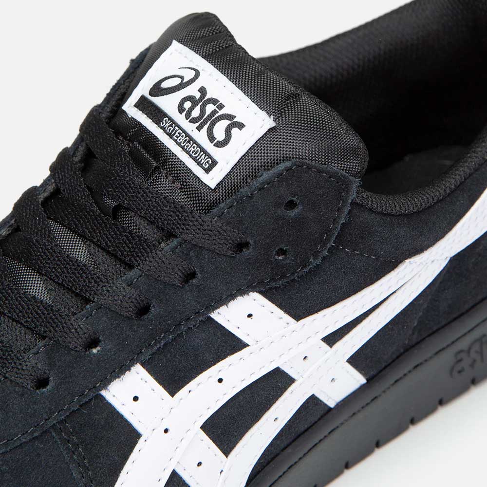 Close-up of the Japan Pro Asics Black White 1201A92001 Suede Skateboarding Shoe, featuring a black suede upper, white ASICS side stripe, white tongue label with black branding, black laces, and a textured suede finish.