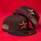 Two KB2 OG Wood Black The Original Houston Astros New Era 5950 Fitted hats, each featuring a gold star logo on the front and an embroidered side patch, are stacked against a solid red background.