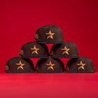 Six KB2 OG Wood Black The Original Houston Astros New Era Hat 5950 Fitted caps, each with a yellow and red star logo and a colorful side patch, are stacked in a pyramid against a solid red background.