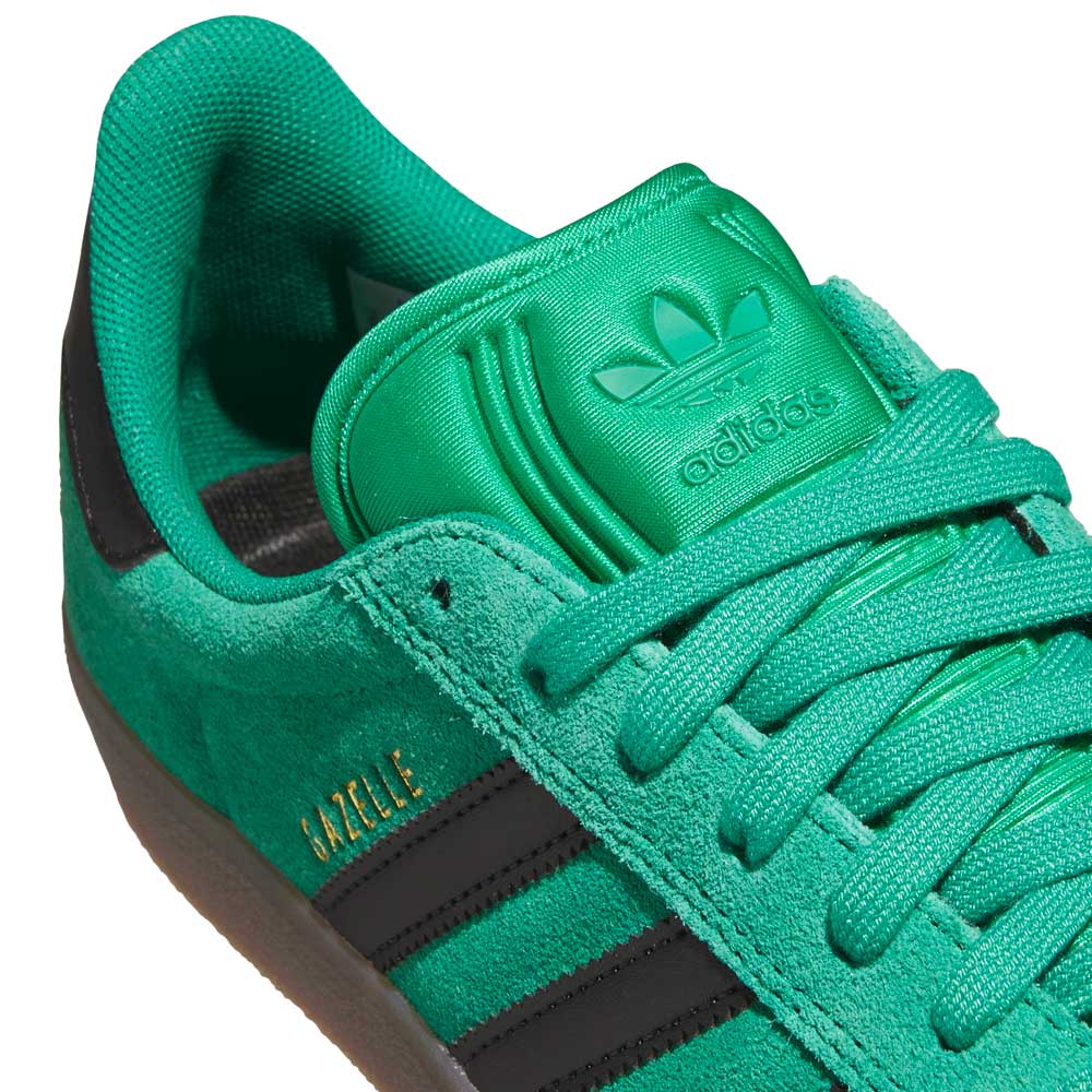 Close-up of KI3206 Green Black Gazelle ADV Adidas Skateboarding Suede Shoes showing black stripes, green laces, and Adidas logo on the tongue. "GAZELLE" in gold sits above the stripes—ideal everyday footwear for style and comfort.
