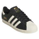 The KK5003 Black White Superstar 80 ADV Adidas Skateboarding Leather Shoes feature three white stripes, gold tongue and heel accents, and a white textured rubber toe cap for a redefined classic skateboarding look.
