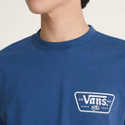 A person wearing the Vans Skateboarding Knu Patch VN000WU85TU1 True Navy Blue Short Sleeve Tee, 100% cotton, with a white patch logo on the left chest. The image shows their upper torso and lower face.