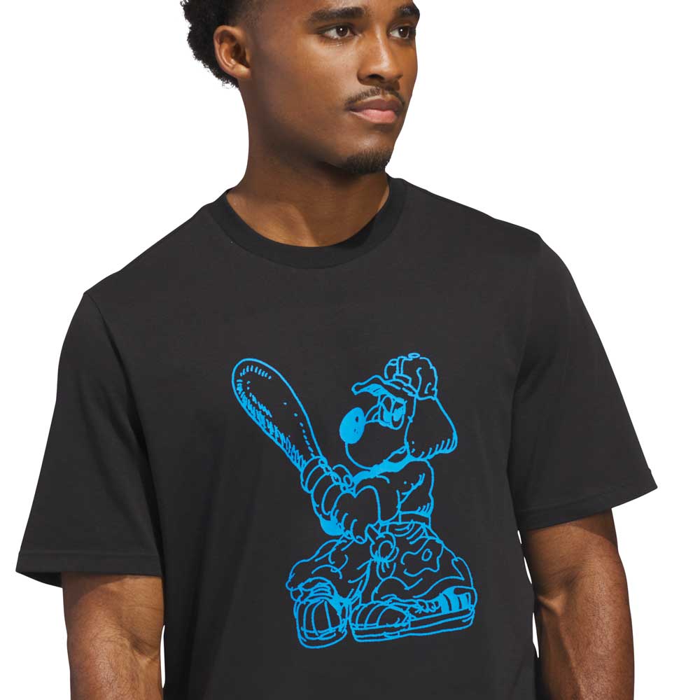A person wearing the Kogan Dog Tee Black Blue KC6304 by Adidas Skateboarding, featuring a blue cartoon dog with a bat graphic, channels skate culture while looking slightly to the side.