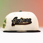 Show your Houston Astros pride with the La Cumbia WS05 Chrome Black Mexico Houston Astros New Era Hat 5950 Fitted. This cream and black fitted cap features “Astros” embroidered on the front in bold black, red, and yellow, accented by a vibrant side patch. The background transitions from green to red for a striking Chrome Black look.