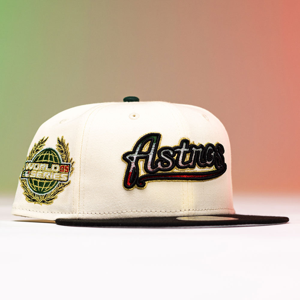 The La Cumbia WS05 Chrome Black Mexico Houston Astros New Era Hat 5950 Fitted is a cream-colored fitted cap in the Chrome Black style, featuring a black brim, “Astros” embroidered on the front, and a World Series globe patch on the side, displayed against a white and red gradient background.