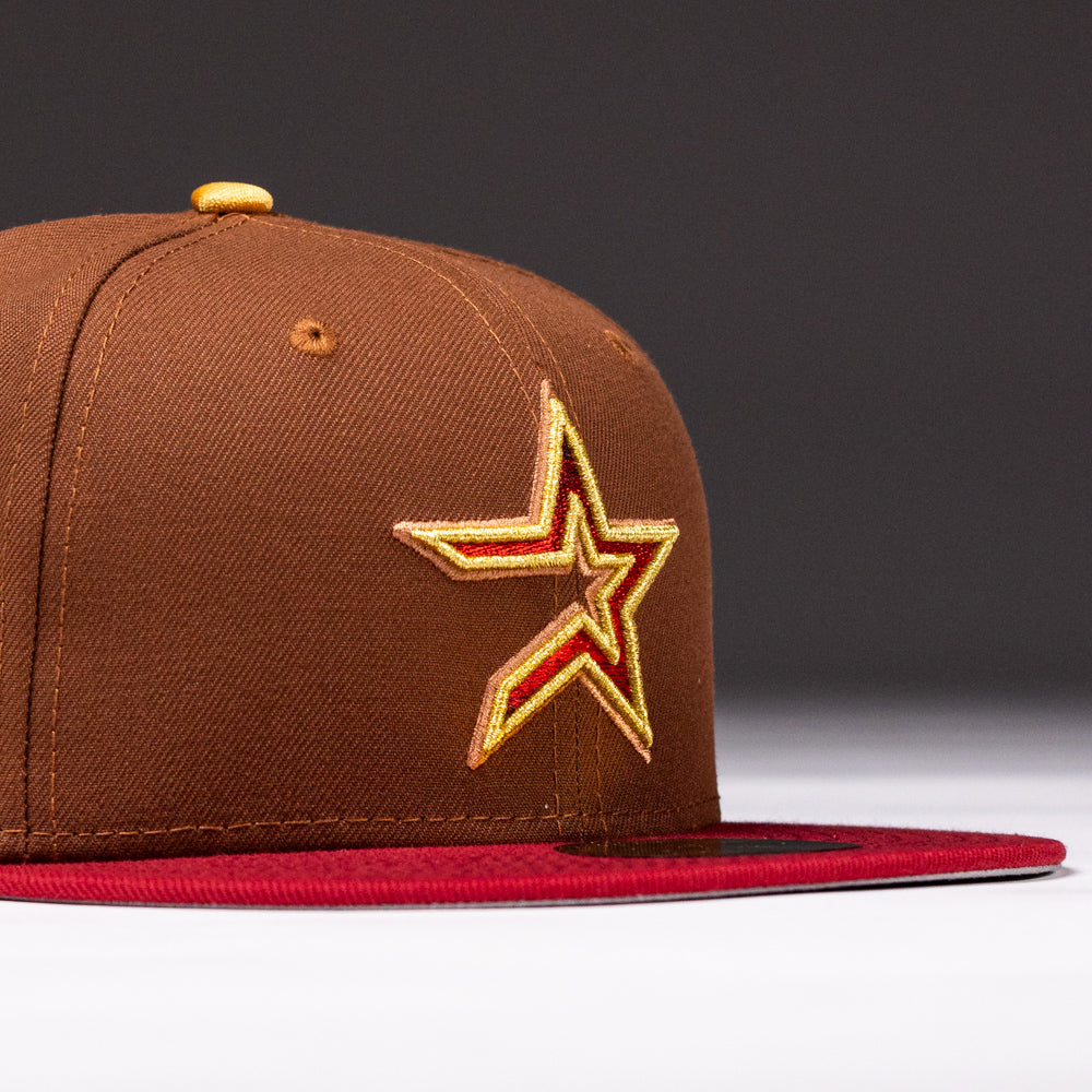 A Bendicion de la Abuela 20th Brown Red Houston Astros New Era Hat 5950 Fitted with a red brim and yellow-outlined star emblem, shown on a plain dark background.