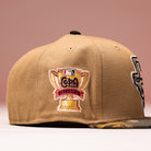 The La Ofrenda Khaki RTC Copa Corpus Christi Hooks New Era 5950 Fitted hat features an embroidered golden trophy patch reading Copa Diversión with the MLB logo above, a camouflage brim, and a soft pink gradient background.