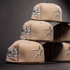 Four La Playa Roja 35th Red Camel Houston Astros New Era 5950 Fitted hats, featuring star outline embroidery and circular patches with text and a star graphic, are stacked in a pyramid shape against a dark background.