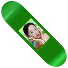 The Lay Accupressure 8.5 Sci-Fi Fantasy Skateboards Deck is a green deck showing a woman framing her face with her hands, black dotted accupressure lines on her skin, and lush green leaves around her.