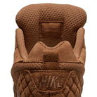 Close-up of the Light British Tan IQ6827200 Paul Rodriguez Zoom Air Low Suede Skateboarding Shoe by Nike, highlighting the textured tongue with embossed text, quilted heel design, and embroidered NIKE logo on the back. The premium leather upper enhances durability and style, while the rubber outsole ensures reliable traction.
