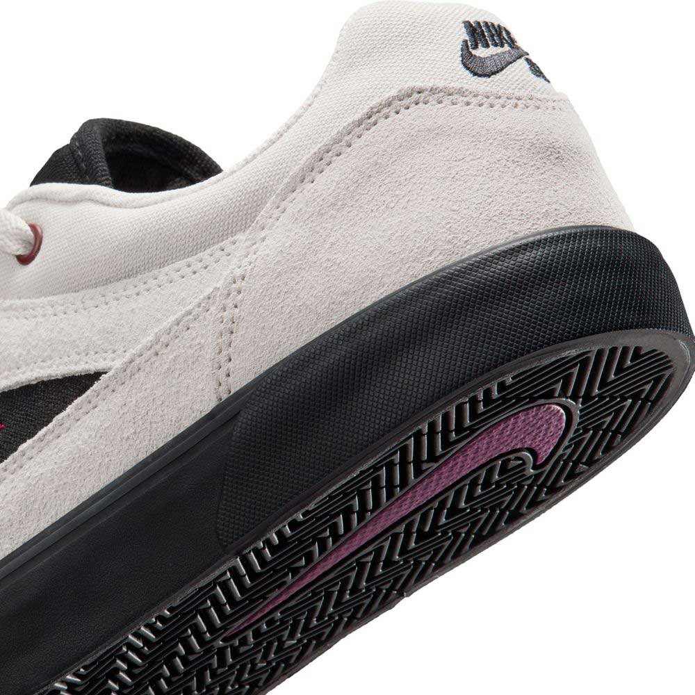 Close-up of the Light Orewood FV6064104 Malor Nike SB shoes, featuring a white and black design, textured black sole, purple swoosh, embroidered heel logo, and a durable suede upper ideal for both style and skate performance.