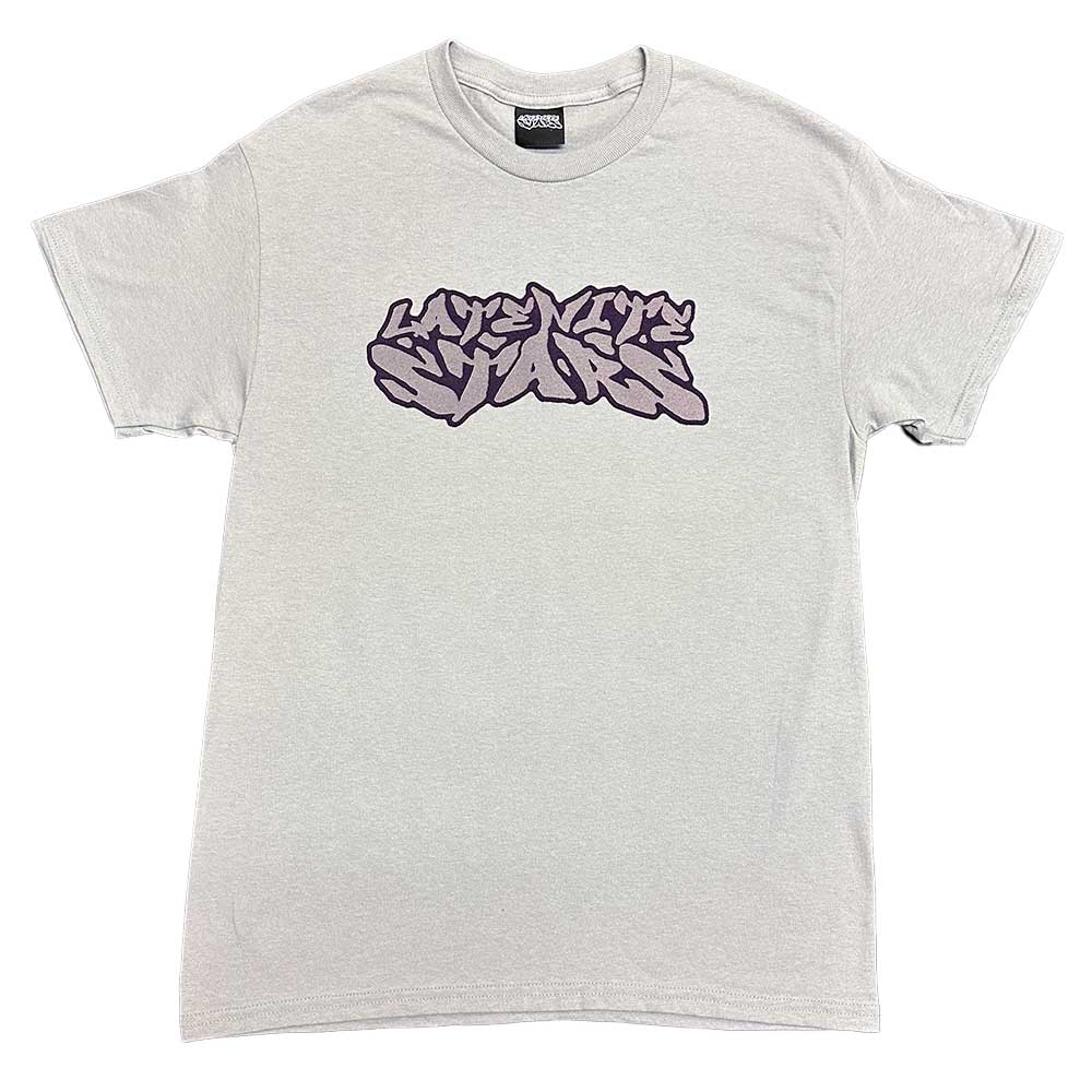 The Logo Tee Gray Purple Late Nite Stars features “LIFETIME SUPPLY” in bold, purple graffiti-style text screenprinted across its light gray-purple chest.