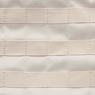 Close-up of textured beige fabric with three parallel rows of rectangular loops—perfect for organizing gear on the Lt Orewood Brown Black FD7544-104 Nike SB RPM Skate Backpack.