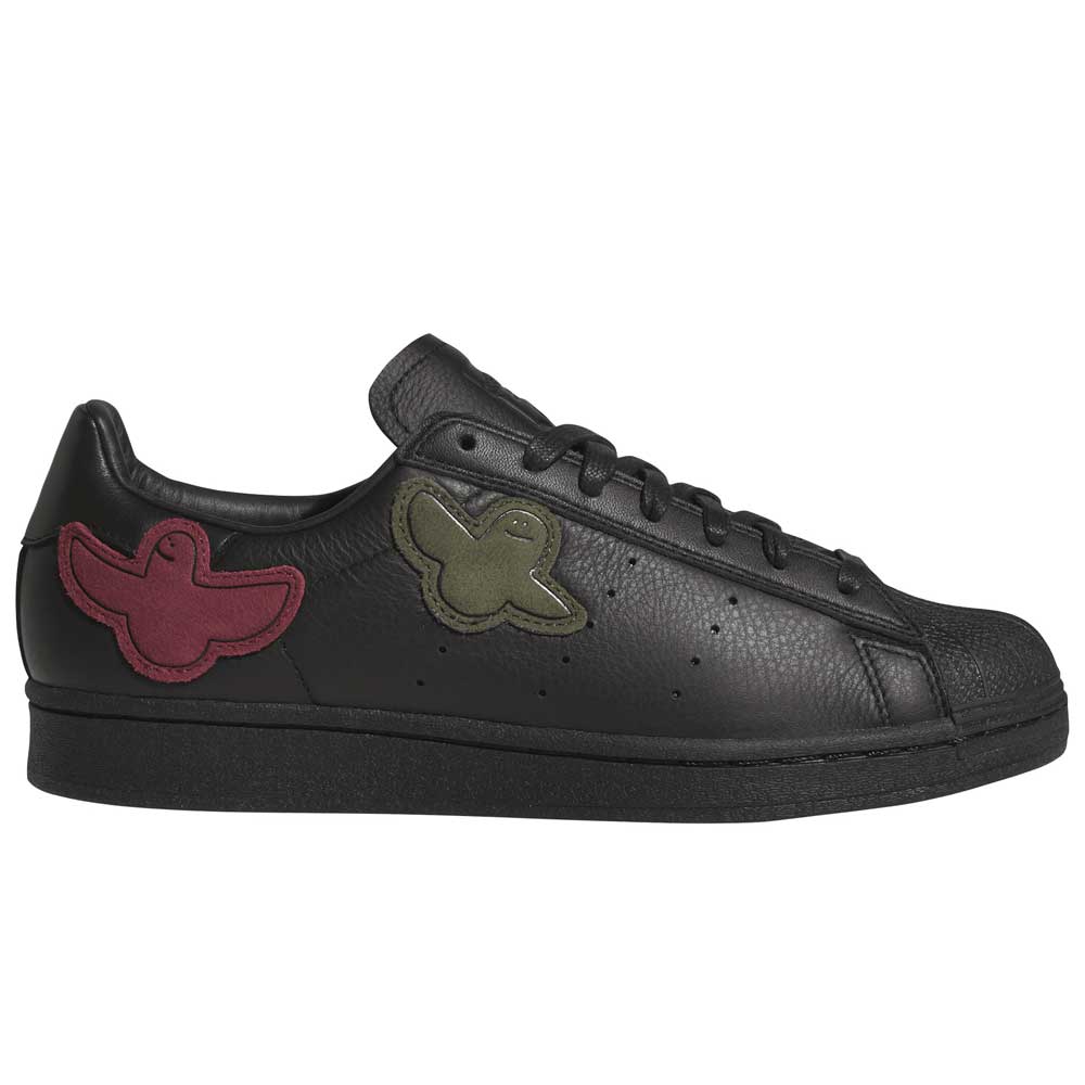 Introducing the Mark Gonzales Black Black Black LA6416 Superstar ADV x Gonz Adidas Skateboarding Leather Shoes Footwear—sleek black leather sneakers from adidas Skateboarding, inspired by adidas Originals, featuring distinctive dark green and dark red bird-shaped patches on the sides, black laces, and an all-black sole—an ideal choice for those seeking stylish yet functional skateboarding footwear.