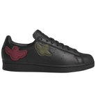 Introducing the Mark Gonzales Black Black Black LA6416 Superstar ADV x Gonz Adidas Skateboarding Leather Shoes Footwear—sleek black leather sneakers from adidas Skateboarding, inspired by adidas Originals, featuring distinctive dark green and dark red bird-shaped patches on the sides, black laces, and an all-black sole—an ideal choice for those seeking stylish yet functional skateboarding footwear.