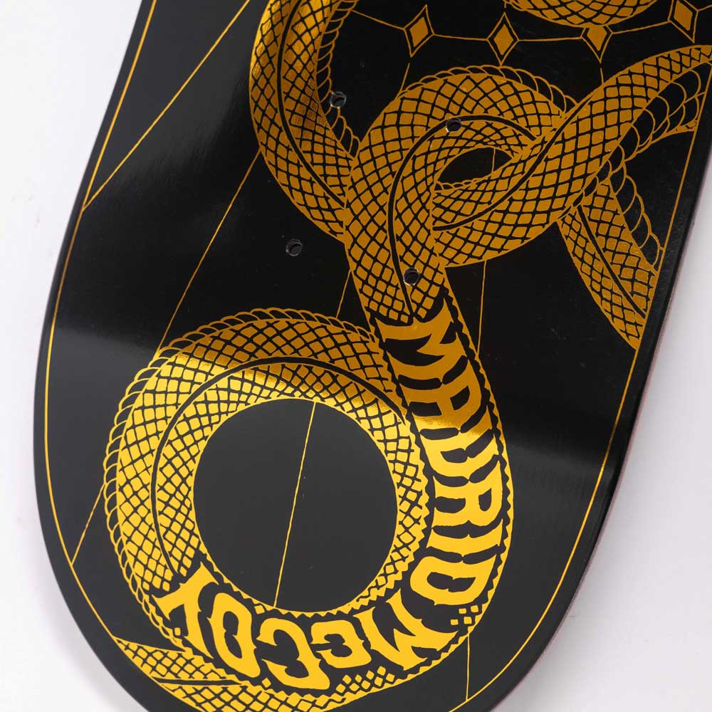 Close-up of the McCoy Snakes VX Deck 8.25in x 31.83in from Santa Cruz Skateboards—features a gold geometric snake on black, with MADRID MCGOY in its body, evoking the iconic style of this signature deck.