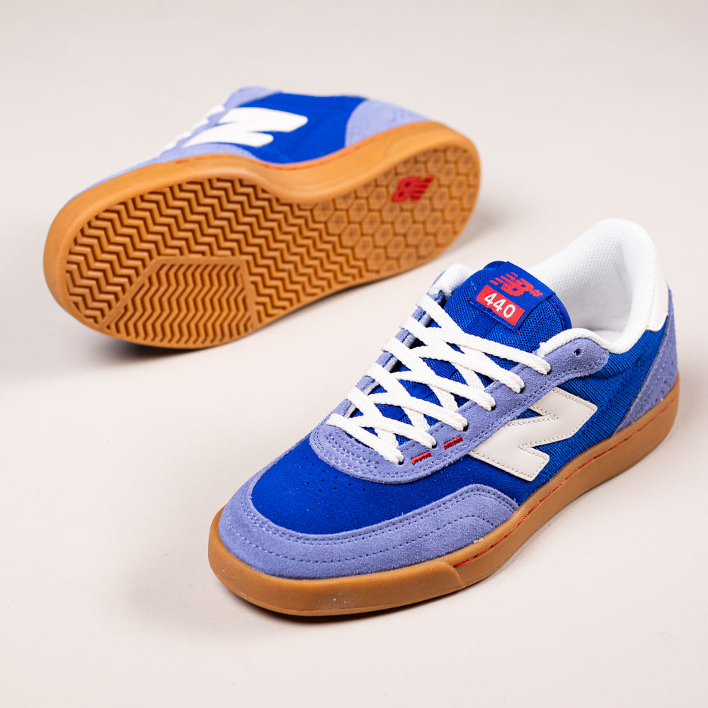 A pair of blue and gray 1010 CR New Balance Numeric Suede Skateboarding Shoes with white laces, ABZORB midsole, white side logos, and durable gum rubber outsoles are shown on a light background—one upright, one revealing the sole.