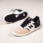 A pair of Incense Black Jamie Foy Cup 306 CBB New Balance Numeric suede skateboarding shoes with beige toes, black laces, white sides, black and green accents, and black soles displayed on a neutral background.