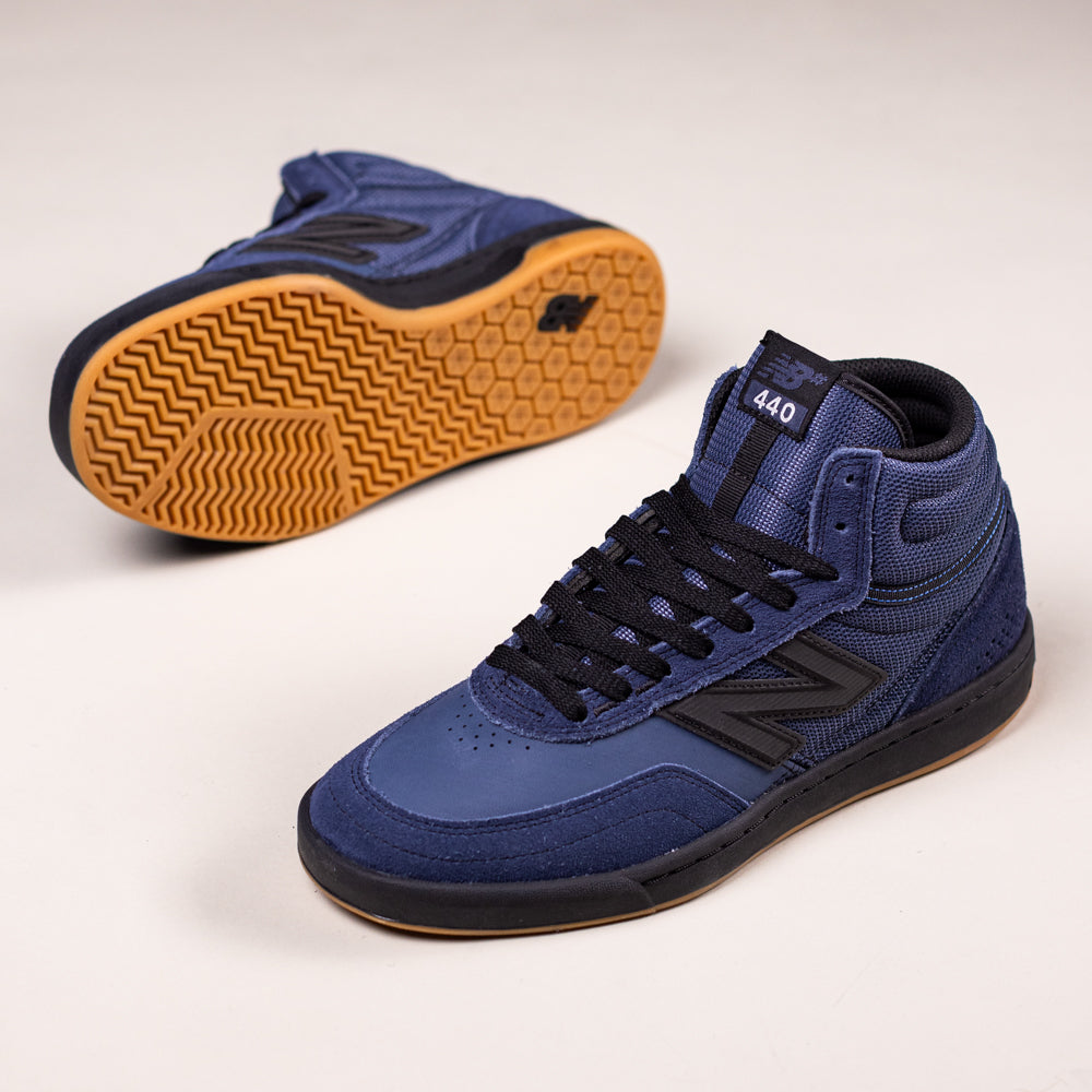 A pair of 440 High Navy Black HNN New Balance Numeric Suede skate shoes with black laces, black soles, gum outsole, and ABZORB midsole. One shoe stands upright; the other lies on its side showing the sole against a white background.