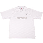 The New Balance Numeric Team Jersey MT61V471ABR is a plain white short-sleeve athletic shirt with a collar, featuring "numeric" in light gray across the chest and a small NB logo above it on the left side.
