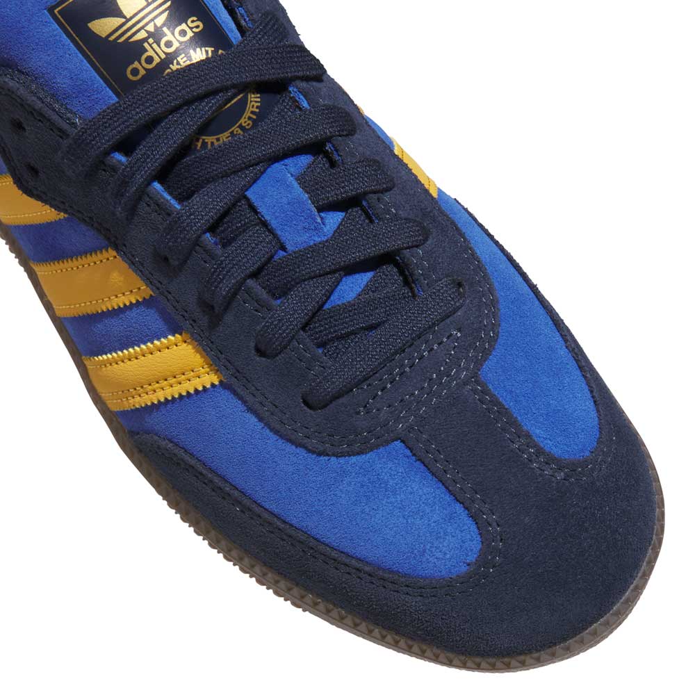 Close-up of Navy Yellow Gum Samba ADV HQ9283 Adidas Skateboarding shoes featuring blue and navy leather-suede, yellow stripes and logo, black laces, a textured brown sole, and signature adidas performance innovation.