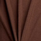 Close-up of soft brown folds form diagonal lines and shadows, emphasizing the relaxed fit and texture of the New Balance Numeric Small Logo Tee Pumperknickel MT53706ABJ—ideal for a casual crewneck style.