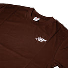 The New Balance Numeric Small Logo Tee Pumpernickel MT53706ABJ is a brown cotton crewneck with a relaxed fit and a small white Numeric logo on the left chest, shown on a plain background.