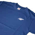 The New Balance Numeric Small Logo Magic Blue Tee MT53706AA4 is a cotton crewneck with a relaxed fit, featuring a small white New Balance logo with motion lines on the left chest and a visible inner neck tag.