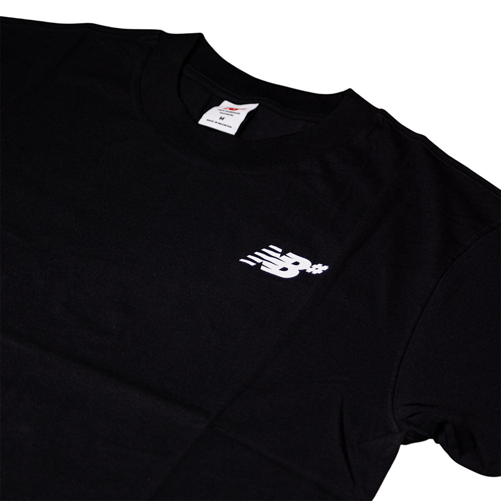 The New Balance Numeric Small Logo Black Tee MT53706BK is a relaxed fit black cotton crewneck t-shirt with a small white New Balance Numeric logo on the left chest and a visible tag inside the collar.