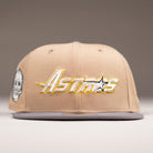 The Chalino Skull Camel Storm Houston Astros New Era 5950 Fitted Hat features "Astros" embroidered in yellow and white, a Chalino Skull patch on the left, plus a flat brim and ventilated eyelets for a signature look.