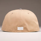 A Chalino Skull Camel Storm Houston Astros New Era 5950 Fitted Hat in beige, seen from the back with a small white rectangular patch near the bottom center against a plain, neutral background.
