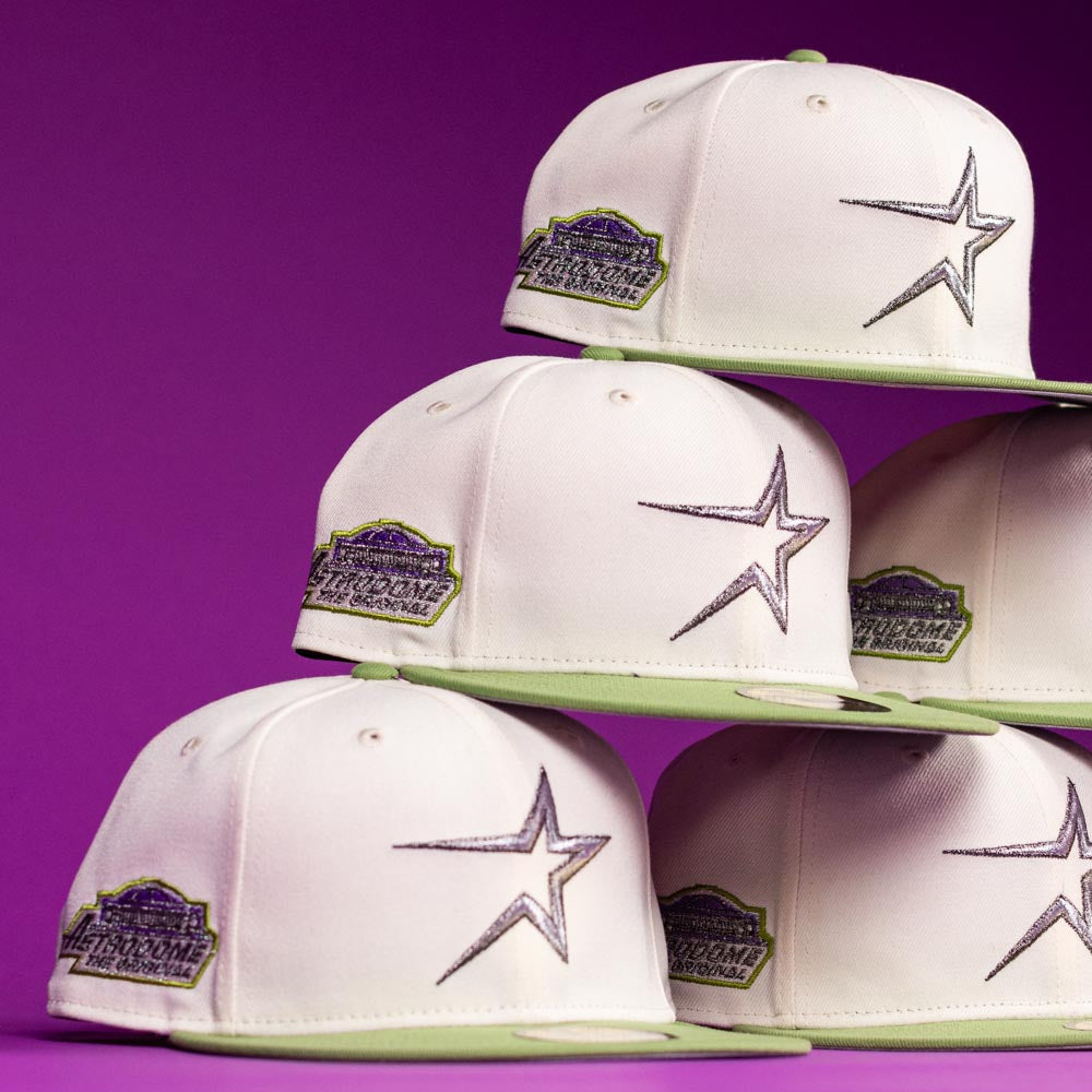 A stack of Matcha Guy Houston Astros New Era 5950 Fitted hats with white crowns, light green brims, a black-outlined star on the front, and a colorful side patch, all set against a purple background.