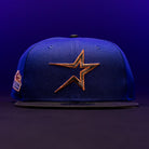 Sure! Here’s the rewritten sentence using the provided product data: The H Town North Houston Astros New Era Hat 5950 Fitted in OG Dark Royal features a gold Houston Astros star logo on the front and a patch on the left side, showcased against a dark purple background.