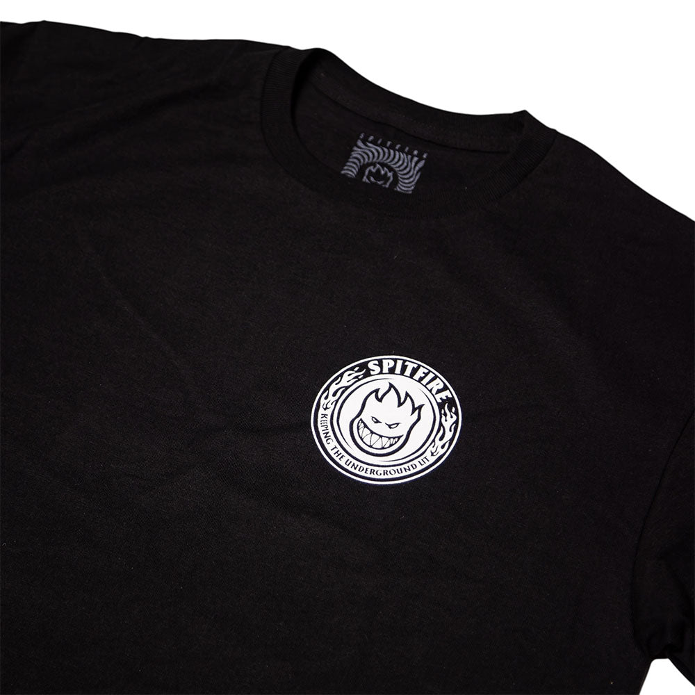 The Southside x Spitfire KTUL Pinwheel Black Tee features a black base with a small circular white Spitfire logo on the chest, showcasing a stylized grinning face and the word SPITFIRE above it—an iconic nod to underground lit pinwheel culture. A matching design is also found on the shirt tag, making this tee ideal for fans of Southside Skatepark and skate style.