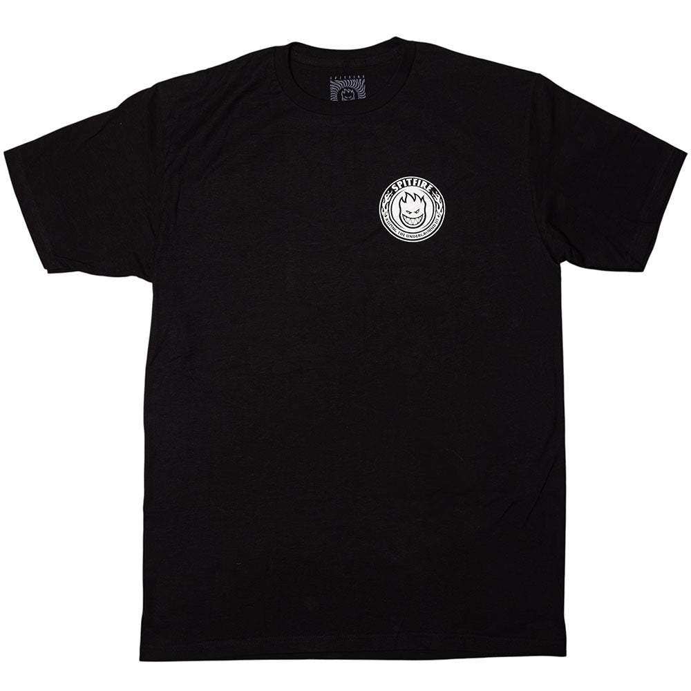 Southside x Spitfire KTUL Pinwheel Black Tee displayed flat on a white background. This black t-shirt features a small white circular logo on the left chest with a stylized smiling face and the word “SATISFYER” around it. Inspired by the creativity of Southside Skatepark, it channels an underground lit pinwheel vibe.