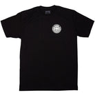 Southside x Spitfire KTUL Pinwheel Black Tee displayed flat on a white background. This black t-shirt features a small white circular logo on the left chest with a stylized smiling face and the word “SATISFYER” around it. Inspired by the creativity of Southside Skatepark, it channels an underground lit pinwheel vibe.