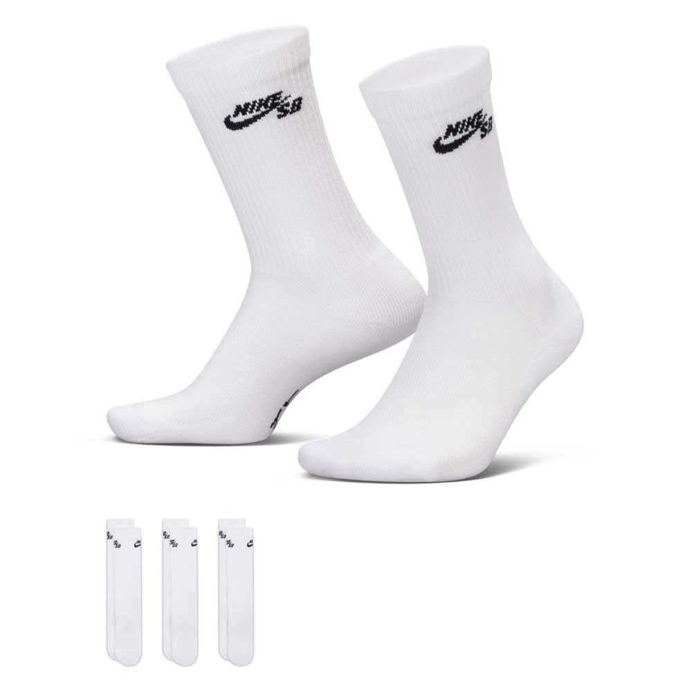 Three pairs of white Nike SB Everyday Elevated crew socks (IR1328910) with black logos, crafted from sweat-wicking fabric for all-day comfort. The socks are modeled on invisible feet, and an extra set of four Nike cushioned socks is shown below to offer added durability and support.
