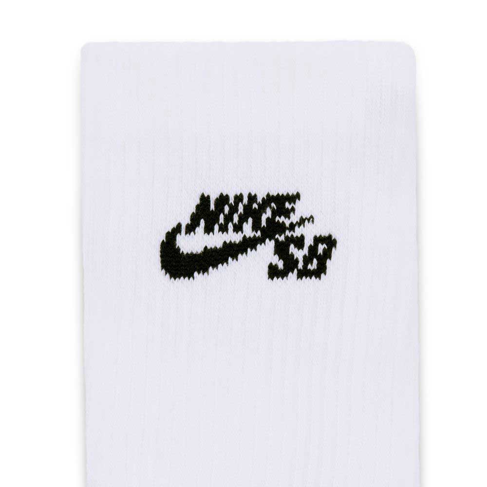 Close-up of a white fabric with a black embroidered Nike SB logo featuring the signature swoosh and stylized lettering, highlighting the premium design of the Nike SB Everyday Elevated 3 Pack IR1328910 White Black Crew Socks for all-day comfort.