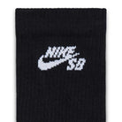 A close-up of a black Nike SB Everyday Elevated Crew Sock from the IR1328900 3 Pack, featuring the white “NIKE” and swoosh logo above the letters “SB” knitted near the top. Made with Dri-FIT technology to help keep your feet dry and comfortable during workouts.