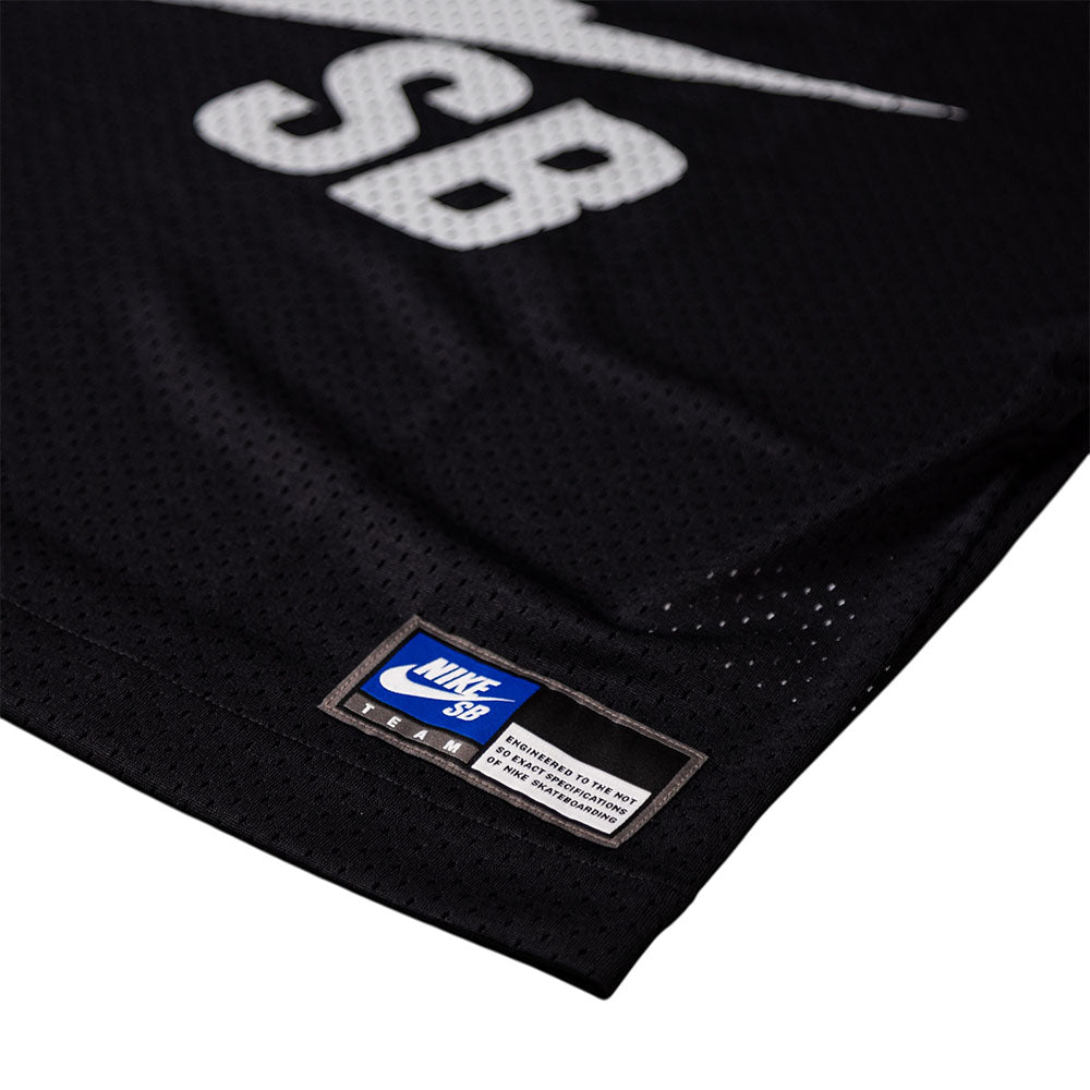 Close-up of the Perforated Cropped Black Jersey IF1349010 T-Shirt Nike SB Skateboarding Tee, featuring a white SB logo, blue and white label near the hem, and imported mesh-textured polyester that's machine washable.