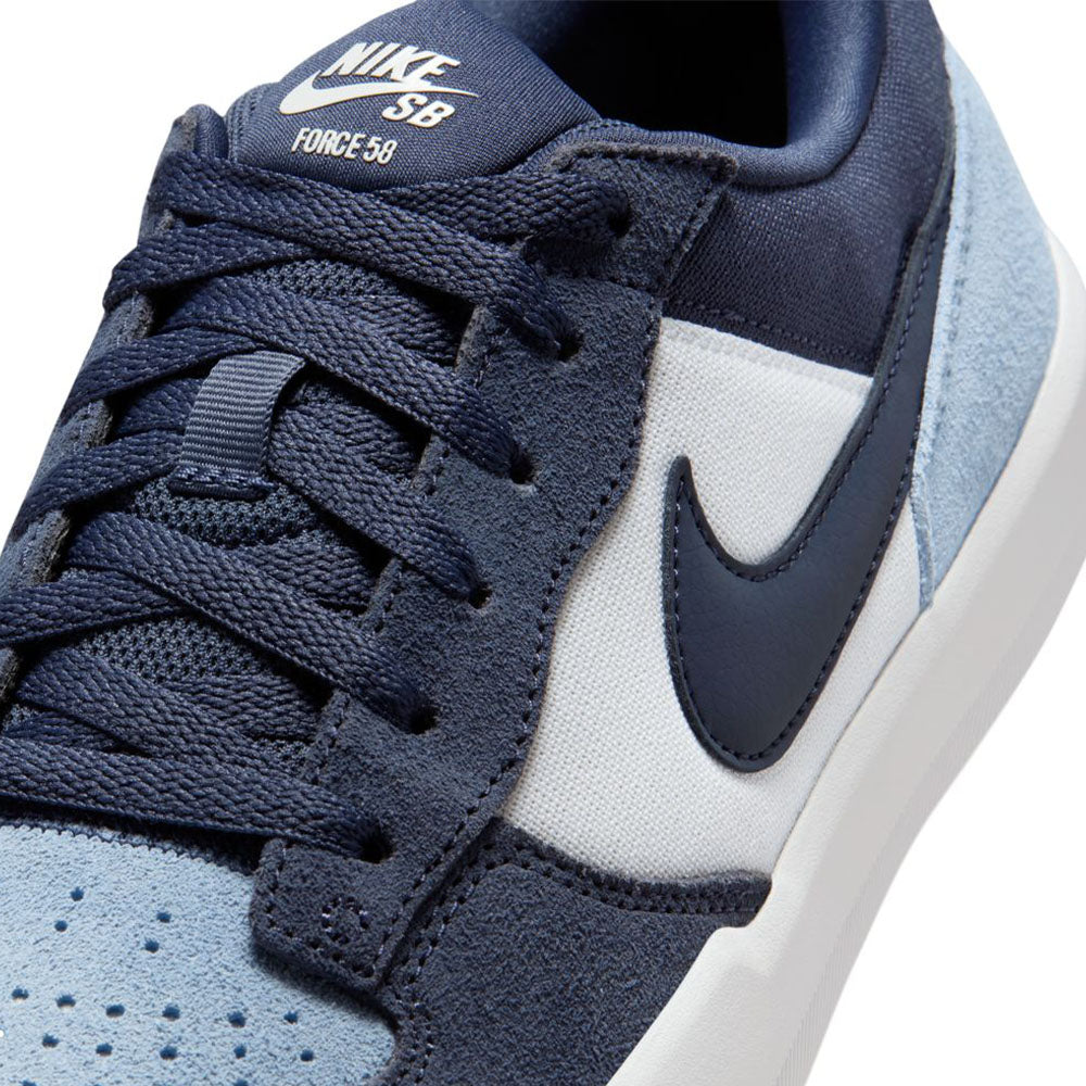 Close-up of the Nike SB Force 58 Light Armory Blue Thunder Photon Dust DV5477-404 suede skateboarding shoes, featuring navy and light blue suede, white midsole, navy Swoosh, and SB Force 58 branding on the tongue.