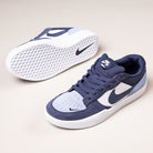 A pair of Nike SB Force 58 Suede Skateboarding Shoes in Light Armory Blue/Thunder Photon Dust (DV5477-404), with one shoe upright and the other on its side showing the textured sole, Swoosh logo, and heritage basketball design.