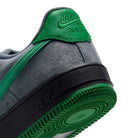 Close-up of the heel and sole of an AF1 Cool Grey Court Green Black IV5289003 Nike SB Suede Skateboarding Shoe, featuring a grey suede upper, a green heel tab, and a black midsole with a green rubber tread.