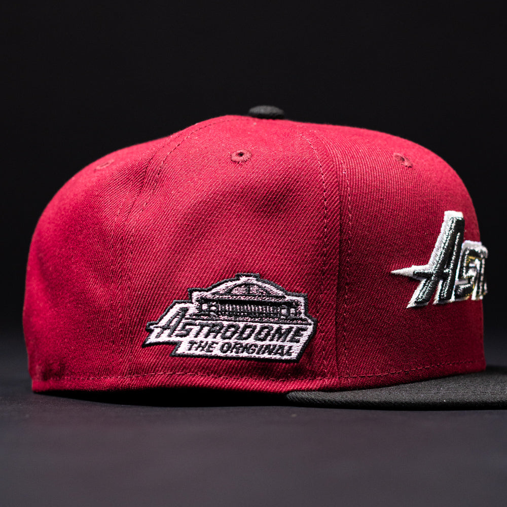 Introducing the Bloodline OG Cardinal Red Houston Astros New Era Hat 5950 Fitted: a maroon and black fitted cap with striking Cardinal Red accents, showcasing part of a silver Houston Astros logo on the front and finished with an Astrodome The Original patch on the side.