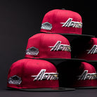 Six Bloodline OG Cardinal Red Houston Astros New Era Hat 5950 Fitted caps, adorned with both the Houston Astros and Astrodome The Original patches, are stacked in a dark setting. The hats feature Cardinal Red crowns paired with black brims and bold white, gold, and silver embroidered lettering and logos.