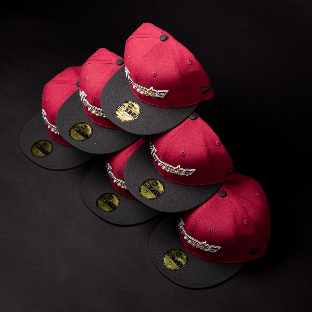 Six Bloodline OG Cardinal Red Houston Astros New Era Hat 5950 Fitted caps are stacked in two rows on a black surface. Each cap features a sticker on the brim and displays the Houston Astros logo embroidered on the front with bold Cardinal Red accents.