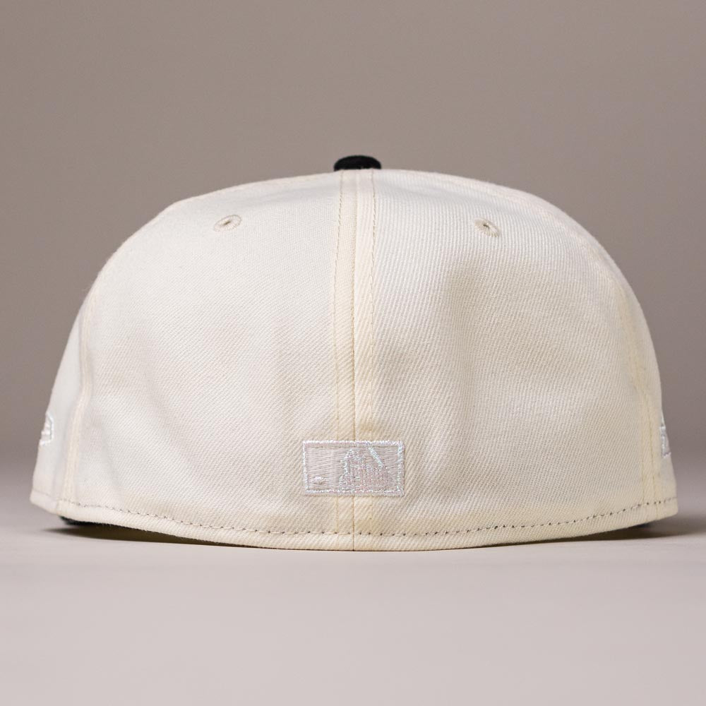 A cream-colored Straight Outta Southside OG Chrome Black Houston Astros 5950 Fitted New Era Hat is shown from the back, featuring two ventilation eyelets and a small embroidered Houston Astros logo at the bottom center near the brim.