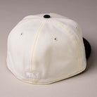 A Straight Outta Southside OG Chrome Black Houston Astros New Era Hat 5950 Fitted is pictured from the back, highlighting its white and black colorway, visible stitching details, and two small vent holes on each side as it rests on a neutral surface.